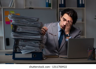 Young male employee working late at office