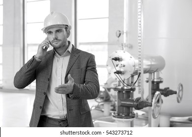 Young male engineer using cell phone in industry