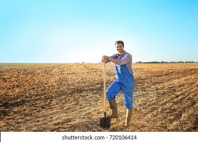 Young Male Farmer With Shovel In Field