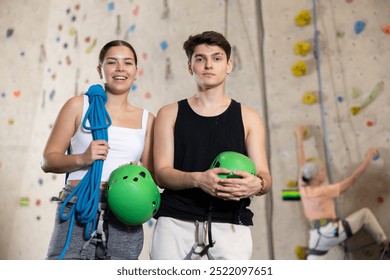 Young male and female climbers with equipment getting ready to climb wall in gym - Powered by Shutterstock