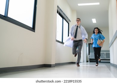 Young male and female professional doctor and surgeon holding clipboard with stethoscope and wearing lab coat and uniform running in hospital hallway and corridor during an emergency - Powered by Shutterstock