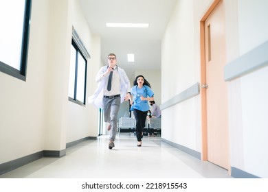 Young male and female professional doctor and surgeon holding clipboard with stethoscope and wearing lab coat and uniform running in hospital hallway and corridor during an emergency - Powered by Shutterstock