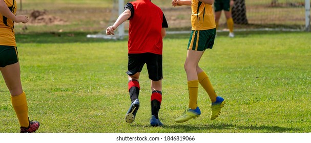 Young male and female soccer players trying for and defending goal posts during a game - Powered by Shutterstock