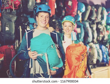 Young  Male And Female In Sports Shop To Choose Reliable Backpacks For Hiking