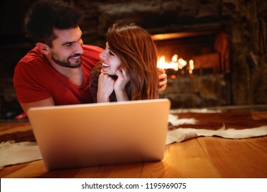 Young male and female watching movie on laptop on winter night  - Powered by Shutterstock