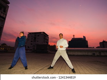 Young male friends doing parkour exercise at balcony on the rooftop on the sunrise - Powered by Shutterstock