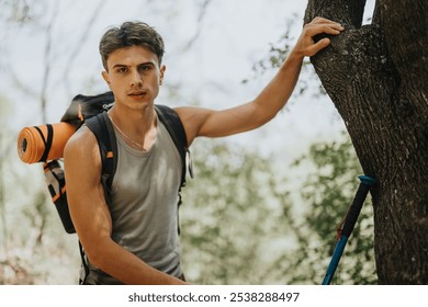 Young male hiker exploring a forest on a sunny summer day, with a backpack and hiking gear, appreciating nature. - Powered by Shutterstock