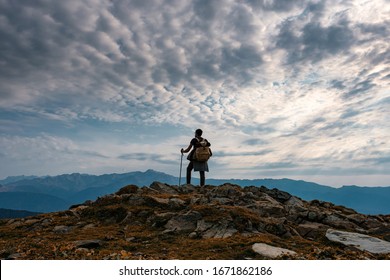 Young male hipster in the mountains in autumn. Discovery Travel Destination Concept. Tourist on the high rocks background. Sport and active life concept. - Shutterstock ID 1671862186