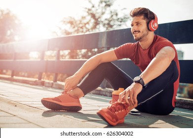 Young male jogger athlete training and doing workout outdoors in city. - Powered by Shutterstock