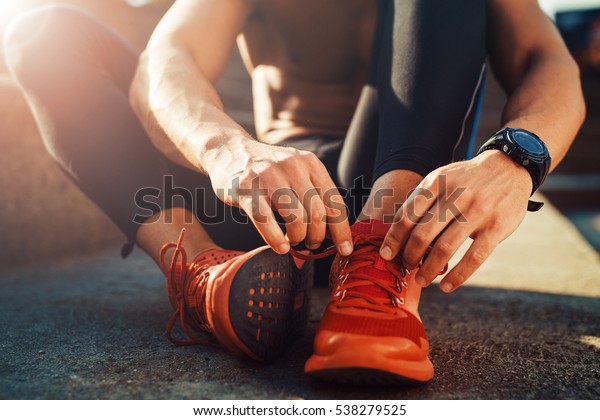 Young male jogger athlete training and doing
workout outdoors in city.