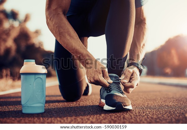 Young male jogger athlete training and doing\
workout outdoors in city.