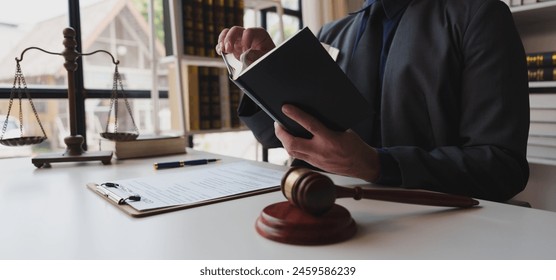 Young male lawyer or business woman working with laptop, searching, analyzing data, reading contract documents, working with law books, hammer of justice Consulting lawyer concept. - Powered by Shutterstock