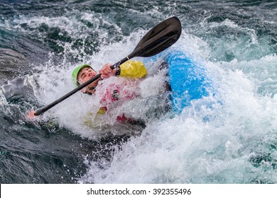 Young Male Man Paddling A Kayak In White Water, The Teenager Is Just Coming Up Out Of A Roll, The Water Is All Around His Face. It Looks Like His Is Drowning Or Sinking.