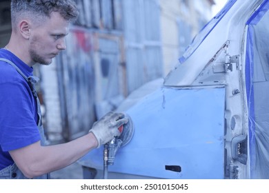 young male master repairs the body of a car van, auto body repair. - Powered by Shutterstock