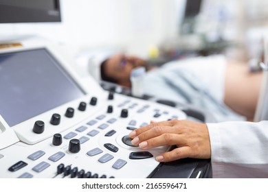 Young male patient lying on bed and having ultrasound examination of abdomen in medical clinic