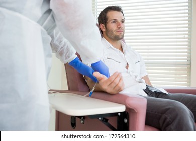 Young male patient receiving intravenous treatment in chemo room - Powered by Shutterstock