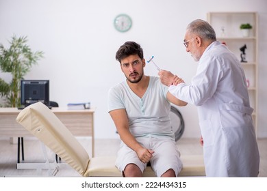 Young Male Patient Visiting Old Male Doctor Neurologist