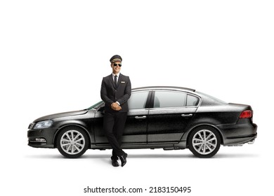 Young Male Professional Chauffeur Leaning On A Black Car Isolated On White Background