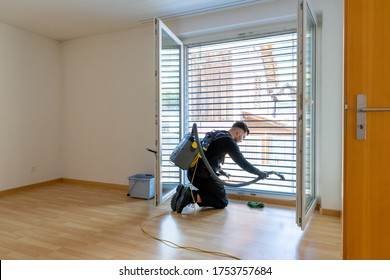 young male professional cleaner vacuuming dirty window blinds and cleaning htem thoroughly