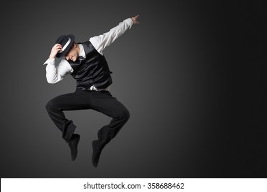 Young Male Professional Dancer Dancing In Studio Isolated On Gray Background.