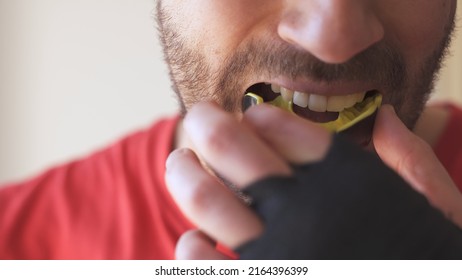 Young male putting mouthguard before boxing sparring training - Shutterstock ID 2164396399