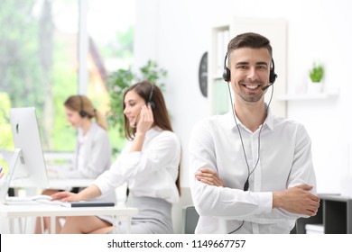 Young male receptionist with headset in office