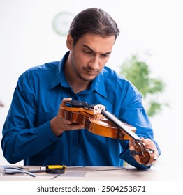 Young male repairman repairing violin - Powered by Shutterstock