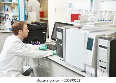 young male researcher works at computer scientific analysing data out scientific test in chemistry laboratory