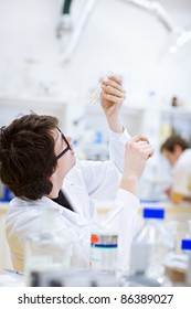 young, male researcher/chemistry student carrying out scientific research in a lab (shallow DOF; color toned image)