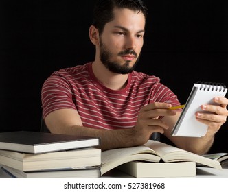 Young Male Reviewing Personal Notes During Studies