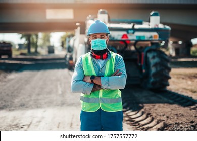 Young Male Road Construction Worker With Face Protective Mask On His Job. Bright Sunny Day. Strong Light.