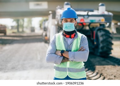 Young Male Road Construction Worker With Face Protective Mask At His Job. Bright Sunny Day. Strong Light.