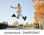 young male roller skater jumping and doing a trick with his inline skates.