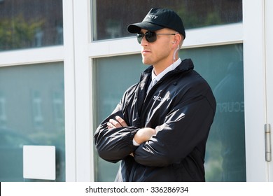 Young Male Security Guard Standing At The Entrance