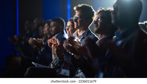 Young Male Sitting in a Crowded Audience at a Science Conference. Delegate Cheering and Applauding After an Inspirational Keynote Speech. Auditorium with Young Successful Specialist. - Shutterstock ID 2236011679