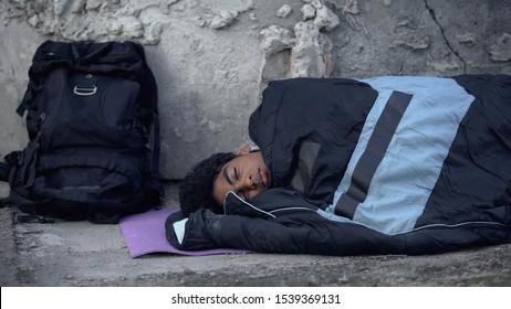 Young Male Sleeping In Bag Lying On Street, Running From Home, Puberty Problems