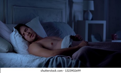 Young male sleeping unwell, suffering nightmare talking in sleep, troubles