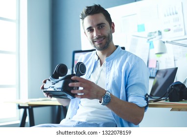 Young male software programmer testing a new app with 3d virtual reality glasses in office.