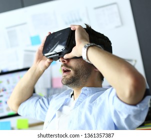 Young male software programmer testing a new app with 3d virtual reality glasses in office.