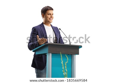 Young male speaker giving a speech on a pedestal isolated on white background