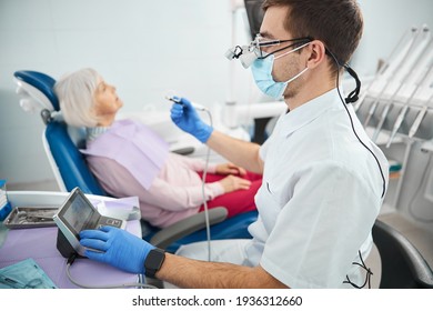 Young Male Stomatologist Clicking On A Dental Drill Unit