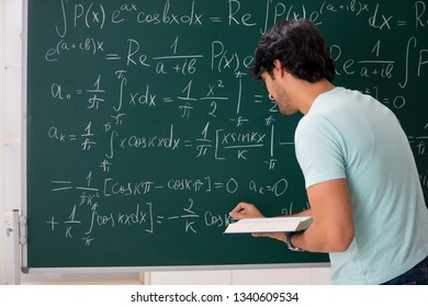 Young Male Student Mathematician In Front Of Chalkboard 