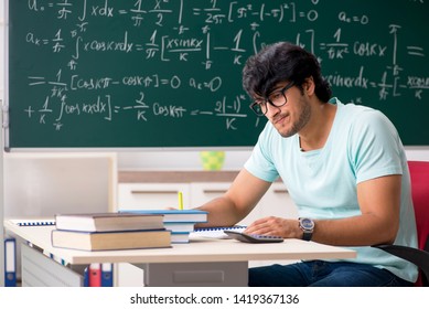 Young Male Student Mathematician In Front Of Chalkboard 