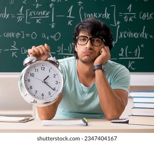 Young male student mathematician in front of chalkboard