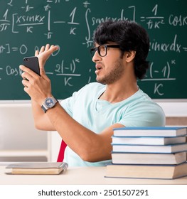 Young male student mathematician in front of chalkboard - Powered by Shutterstock