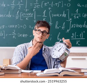 Young male student studying math at school