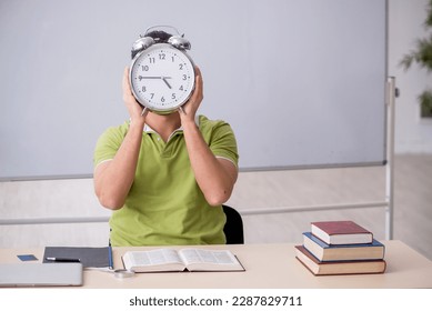 Young male student in time management concept - Powered by Shutterstock