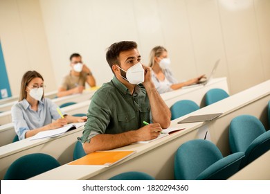 Young male student wearing face protective medical mask for virus protection at lecture hall