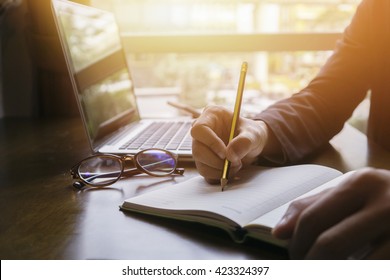 Young male student writes information from portable net-book while prepare for lectures in University campus,hipster man working on laptop computer while sitting in cafe,vintage color,selective focus - Shutterstock ID 423324397