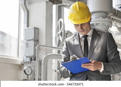 Young male supervisor writing on clipboard in industry - Powered by Shutterstock